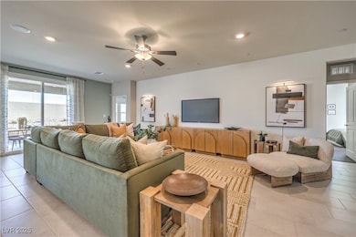 Living room featuring ceiling fan, light tile patt