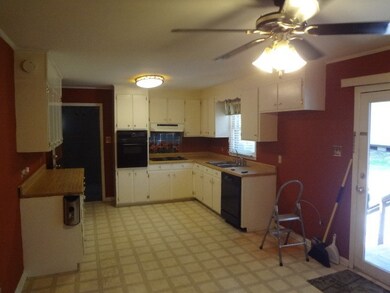 Standing in breakfast area look at working area of kitchen.