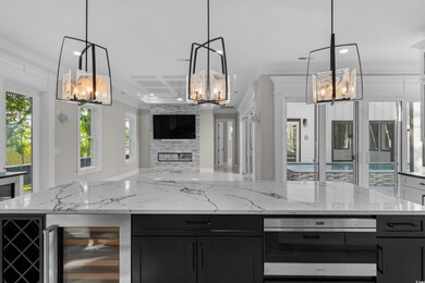 Kitchen featuring a chandelier, dark cabinets, ope