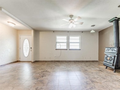 Foyer entrance with a wood stove, a textured ceili