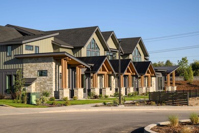 View of front facade with stone siding, board and batten siding, and a metal roof