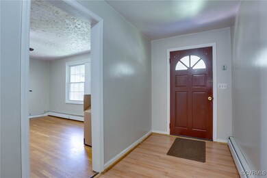 Foyer entrance featuring a baseboard heating unit,