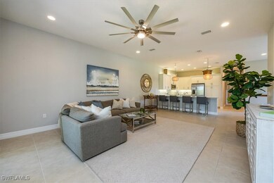 Living room featuring ceiling fan, light tile patt