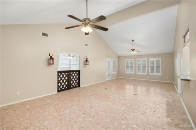 Unfurnished living room featuring light tile flooring, ceiling fan, and high vaulted ceiling