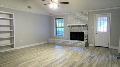 Den with fireplace, built in shelves, door leads t