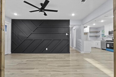 Living room with a ceiling fan, visible vents, lig