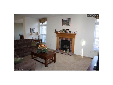 Bright great room with tall windows and fireplace.