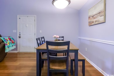 Dining area with wood finished floors, baseboards, and vaulted ceiling