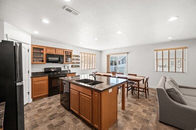 Kitchen featuring black appliances, quartz countertop, and wood cabinetry.