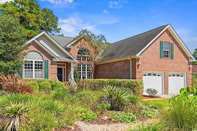 Traditional home featuring brick siding, a shingled roof, and an attached garage