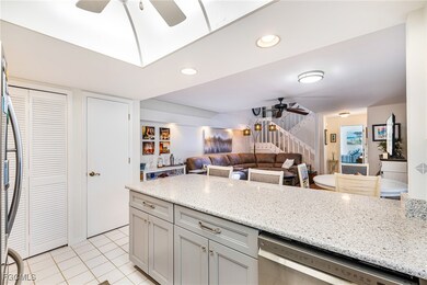 Kitchen featuring a ceiling fan, stainless steel appliances, light tile patterned flooring, light stone counters, and gray cabinetry