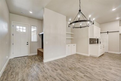 Foyer entrance with a notable chandelier, light ha