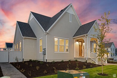 View of front of property with stucco siding, a shingled roof, and a gate
