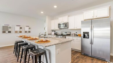 Kitchen with white cabinetry, a kitchen island wit