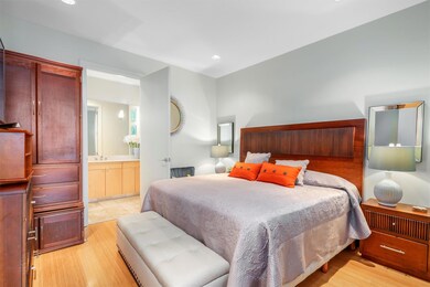 Bedroom with light wood finished floors and ensui