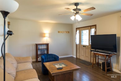Living room featuring dark wood finished floors and a ceiling fan
