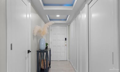 Corridor featuring light tile patterned floors and a raised ceiling