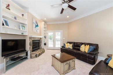 Family room with stone surround fireplace & patio 