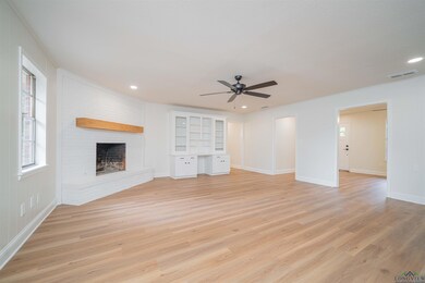 Unfurnished living room with light wood finished floors, a ceiling fan, a fireplace, and recessed lighting