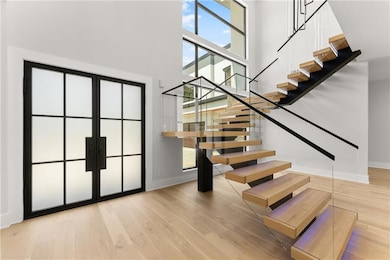 Stairs featuring a high ceiling, wood finished floors, and french doors