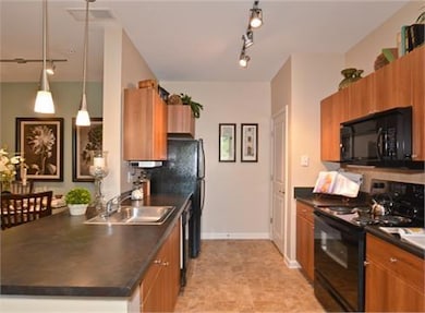 Kitchen featuring decorative light fixtures, black