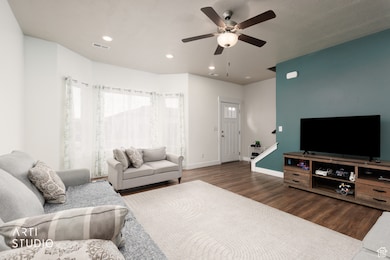 Living room with wood finished floors, recessed lighting, and ceiling fan