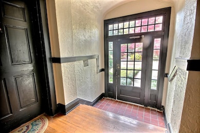 Foyer entrance featuring a textured wall and hardwood / wood-style flooring