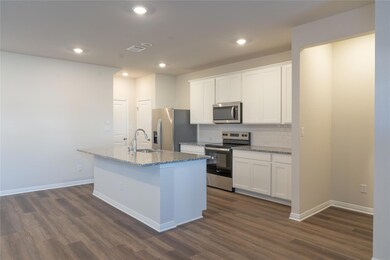 Kitchen with an island with sink, white cabinets,