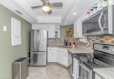 Kitchen with open shelves, appliances with stainless steel finishes, white cabinetry, a tray ceiling, and recessed lighting
