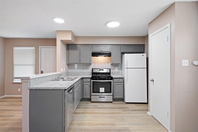 Kitchen featuring a sink, gray cabinetry, stainle