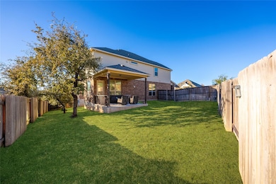 Rear view of house featuring a fenced backyard, a patio, and brick siding