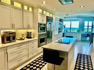 Kitchen featuring backsplash, white cabinetry, a center island, built in fridge, and recessed lighting