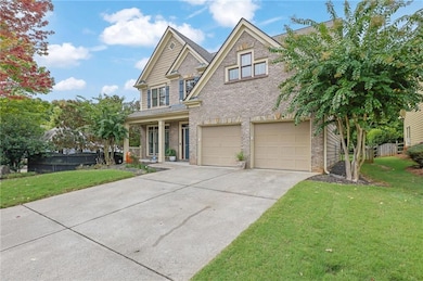 View of front facade featuring brick siding, a porch, concrete driveway, and an attached garage
