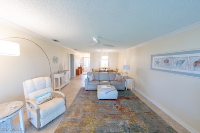 Living room with ceiling fan, a textured ceiling,