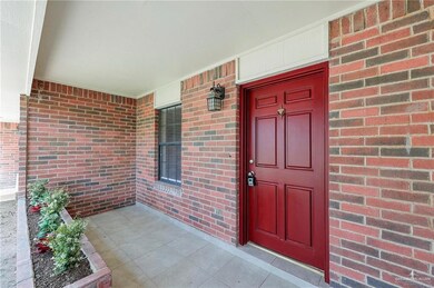 Property entrance featuring brick siding and a porch