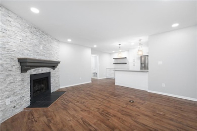 Unfurnished living room featuring dark wood finished floors, a fireplace, and recessed lighting