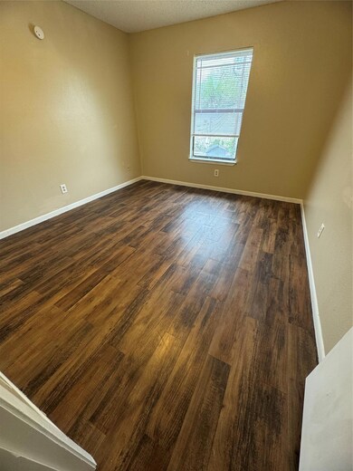 Spare room featuring dark wood-type flooring, bas