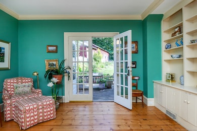 Built in book cases and seating area near the French doors invites readers.