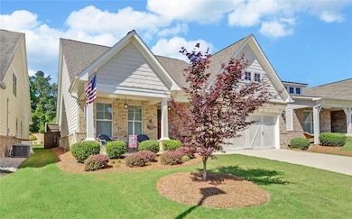 Craftsman inspired home featuring covered porch, a front lawn, driveway, brick siding, and roof with shingles
