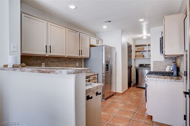 Kitchen leading to the half bath downstairs and th