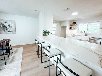 This gorgeous kitchen boasts beautiful quartz countertops and a roomy breakfast bar complete with open shelving for showcasing your favorite items in style.