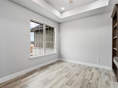French doors lead you into the office. Office features tray ceiling, built-in desk and floor to ceiling custom shelving.
