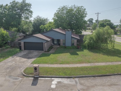View of front of house with brick siding, an attached garage, concrete driveway, and a chimney