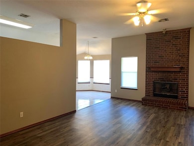 Unfurnished living room featuring vaulted ceiling, wood finished floors, baseboards, and a ceiling fan