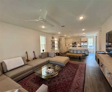 Living room with dark wood-style floors, recessed