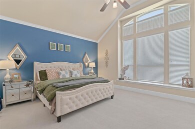 Primary bedroom with large windows, vaulted ceilin