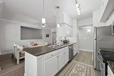 Kitchen featuring a peninsula, white cabinetry, s