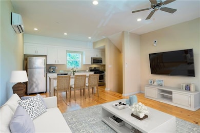 Living room with a ceiling fan, a wall mounted AC,