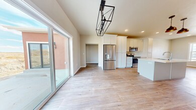 Kitchen featuring stainless steel appliances, white cabinets, light wood-type flooring, recessed lighting, and decorative light fixtures