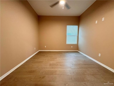 Spare room with wood-type flooring and ceiling fan